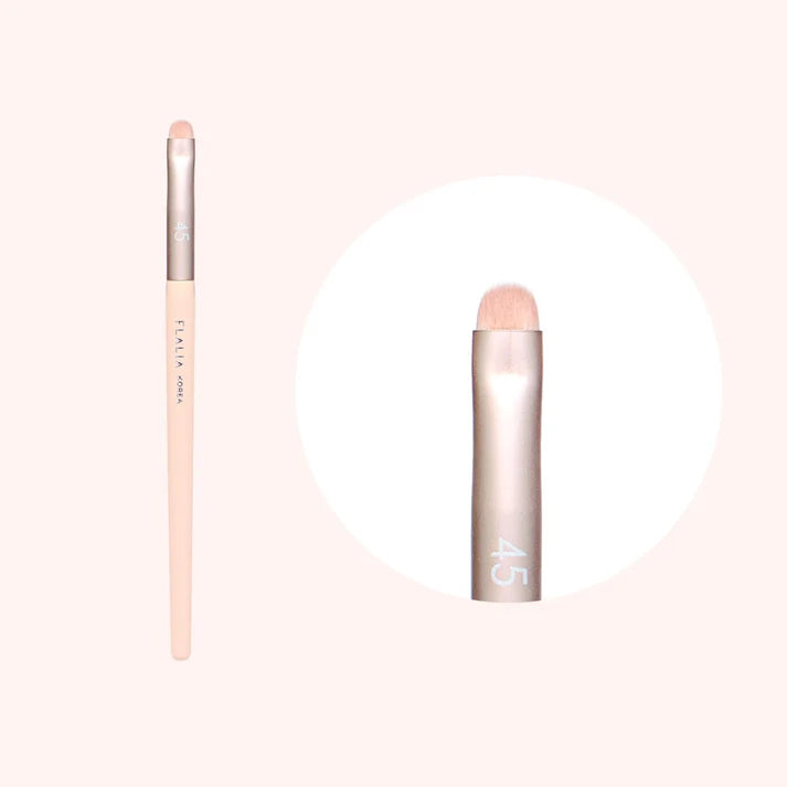 An image showing a Flalia Muhly #45 Point Shadow Brush, with a pale pink handle and a beige brush head, presented against a white background.